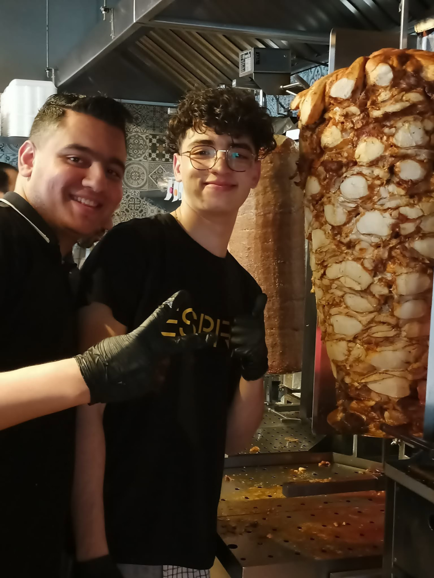 Dwóch pracowników Hadda Kebab przy rożnie