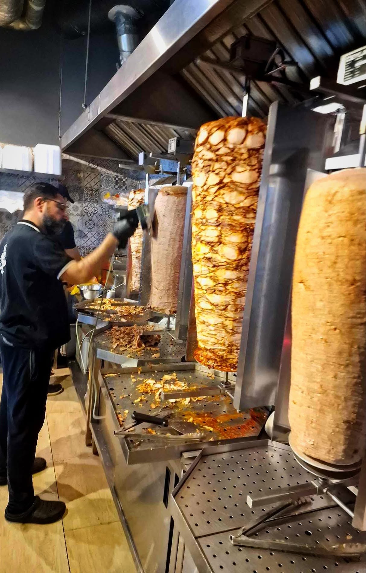 Obsługa Hadda Kebab przygotowująca mięso przy rożnach